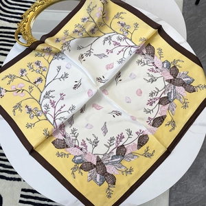 Gelbes 70cm Satin-Halstuch mit Blatt- und Beerenmuster auf einem weißen Tisch