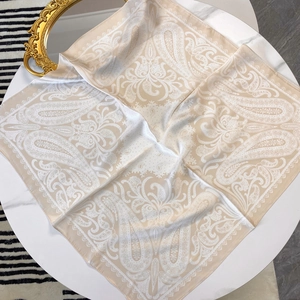 Carré de soie satiné à motif paisley champagne 70cm présenté sur une table avec miroir