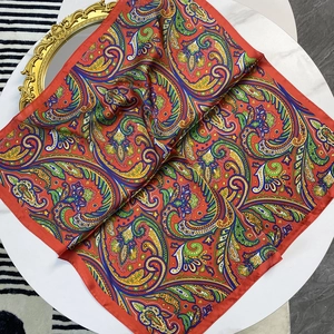 Detail of red paisley satin silk scarf with intricate ethnic floral patterns and hem