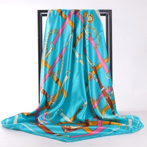 Carré de soie satinée bleu sarcelle avec motifs de chaînes dorées et roses sur présentoir