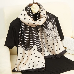 Écharpe en soie à pois et motifs géométriques noir et beige sur vêtement noir élégant