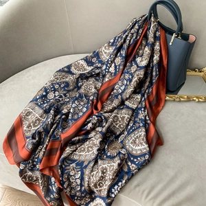Vintage paisley print long silk scarf draped on a sofa for an elegant lifestyle look