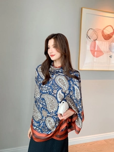 Detail of silk-like paisley pattern shawl in navy blue with elegant orange border