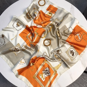Carré de soie satinée avec motifs géométriques orange vintage sur fond de marbre blanc