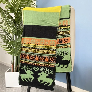 Détail d'une écharpe d'hiver en maille avec motifs jacquard de rennes, cœurs et flocons