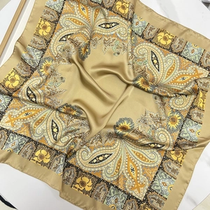 Carré de soie satiné doré 70cm avec motifs paisley vintage sur surface en marbre