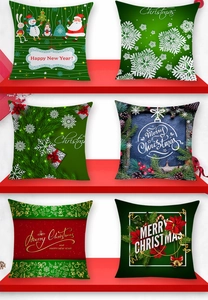 Detail of six Christmas pillow covers featuring Santa and reindeer on red shelves