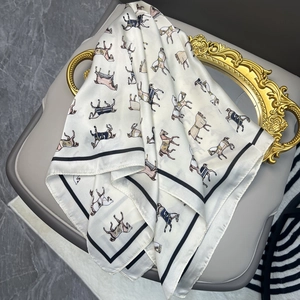 Satin silk square scarf featuring equestrian horse print and black border on a chair