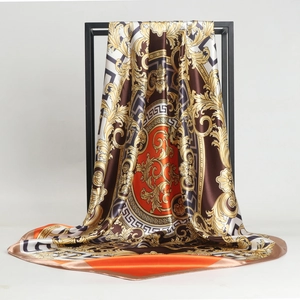Foulard quadrato in seta satinata barocca con motivi oro appeso su cornice