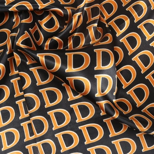 90cm black satin square scarf featuring orange letter D print and elegant draping texture