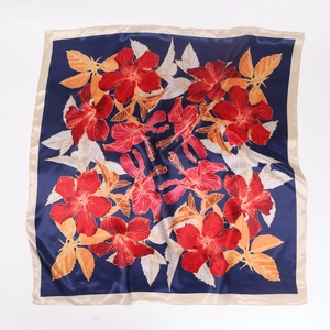 Detailed close-up of dark blue satin silk square scarf with vibrant red hibiscus flowers