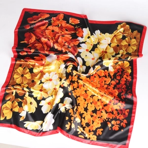 Détail d'un foulard en soie à imprimé floral de coquelicots rouges sur satin noir
