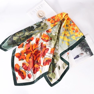 Détails de l'imprimé floral orange sur un foulard carré en aspect soie de qualité