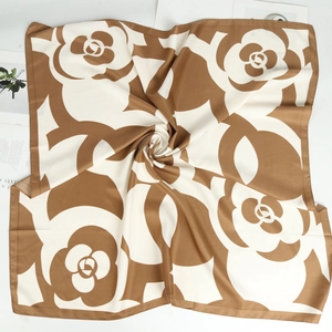 Elegante foulard in seta cammello e bianco con motivi a camelia in una piega a spirale