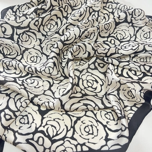 Élégant foulard en soie camélia avec motif rose noir et blanc et fini satiné