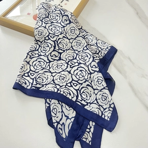 Écharpe en soie à motif camélia bleu et blanc sur surface en marbre élégante