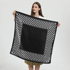 Detailansicht eines 90cm schwarz-weißen Satin-Halstuchs mit Punkten, gehalten von Model