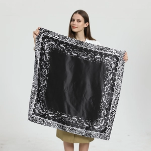 Detail eines 90 cm großen Satinschals mit schwarz-weißem Leopardenmuster und Schnörkelmotiven