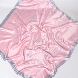 Detail of satin square scarf with geometric spiral lines and grey edge on pink background