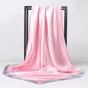 Pink satin square scarf with geometric gray lines hanging on a minimalist display stand