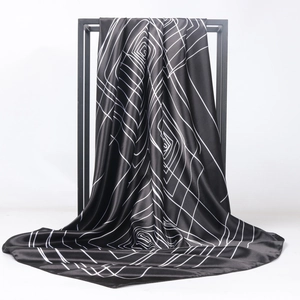 Minimalist geometric spiral print silk satin scarf hanging on a display stand