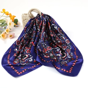 Deep blue Russian square scarf with vintage paisley and red floral prints on straw basket