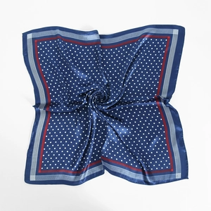 Detail of blue satin square scarf featuring white polka dots and striped border texture