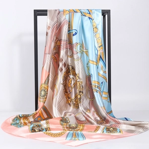 Satin silk scarf with vintage equestrian belt print hanging on a metal display frame