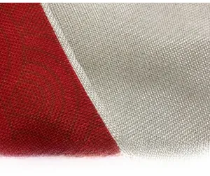 Detail of red polyester fabric and beige linen with white handmade stitching finish