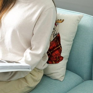 Nordic Christmas pillow cover with reindeer cartoon and plaid scarf on blue sofa