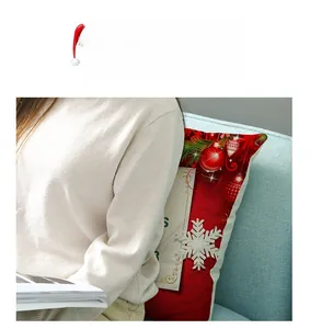 Detail of red Christmas pillowcase with snowflake and pine needle prints on sofa