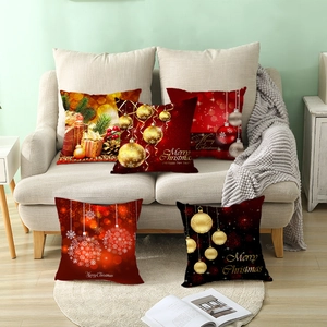 Housses de coussin de Noël rouge et or sur un canapé beige dans un décor festif et chaleureux