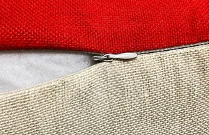Detail shot of invisible zipper closure on red and beige linen blend cushion cover