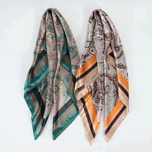 Detailed close-up of vintage paisley patterns on satin silk scarves with fine edge stitching