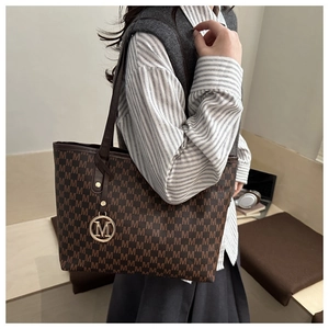 Detail of the large printed tote bag featuring high-capacity interior and M-pattern print