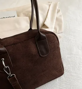 Vue détaillée de la texture daim marron foncé et des coutures de précision du sac