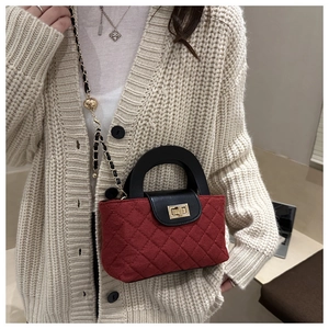 Modella con borsa a tracolla in velluto rosso trapuntato con patta in pelle nera e oro