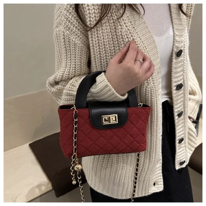 Dettaglio mini borsa trapuntata rossa con patta in pelle nera e chiusura dorata a scatto