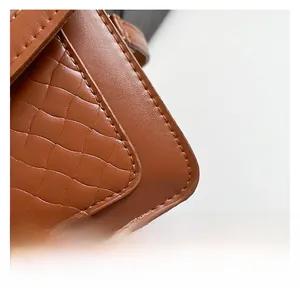 Dettaglio in pelle marrone scuro con trama a onde e cuciture rifinite con cura