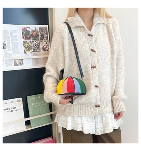 Detailed view of creative colorful umbrella-shaped crossbody bag and beige knit cardigan