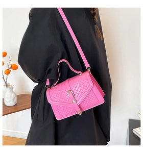 Borsa a tracolla rosa acceso con trama intrecciata e fibbia dorata indossata dal modello
