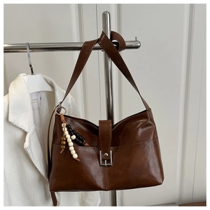 Détail du cabas en cuir PU marron avec boucle métallique et pendentif en perles