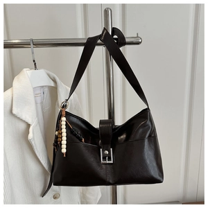 Détail du sac cabas marron foncé avec boucle en métal et gland à franges perlées