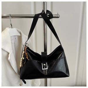 Détail du sac cabas noir brillant avec boucle argentée et perles décoratives en bois