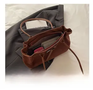 Detailed view of the brown suede tote bag showing its large interior capacity and texture