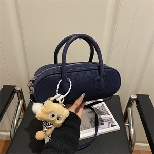 Minimalist navy blue cylinder handbag with a cute plush bear charm and pearl chain