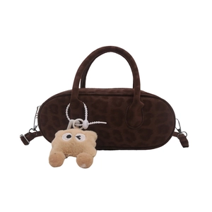 Brown leopard print plush baguette bag with a cute monster keychain and top handles