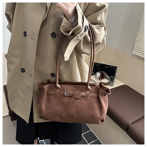 Close-up of retro brown frosted suede shoulder bag with metallic buckle detail