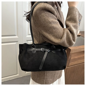 Close-up of black frosted suede underarm bag with leather strap and metal buckle detail