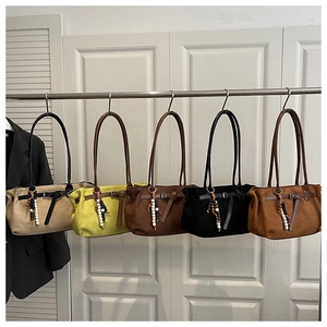Detail of suede handbags in five colors with beads and boho-style fringe decorations